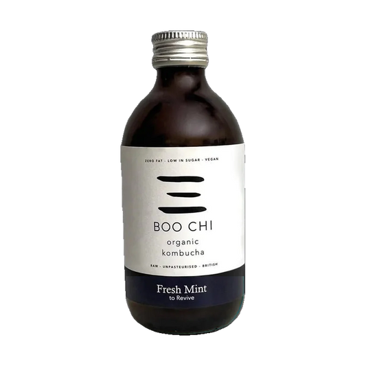 A dark glass bottle of Boo Chi Fresh Mint organic kombucha with a white label, a navy band and a silver cap.
