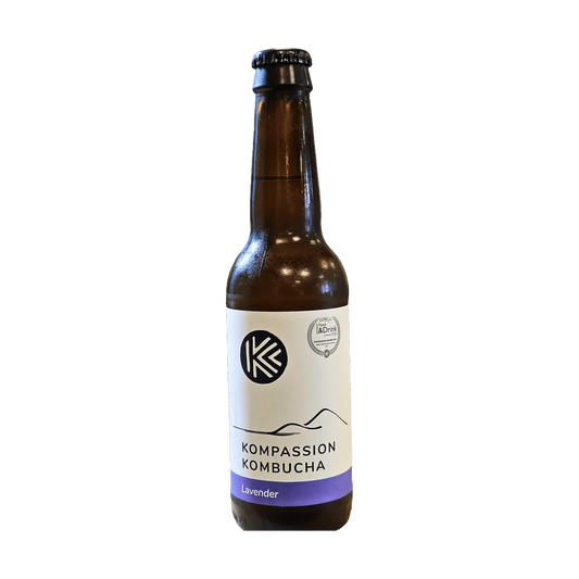 A brown bottle of Kompassion Lavender kombucha with a white label and a purple band.