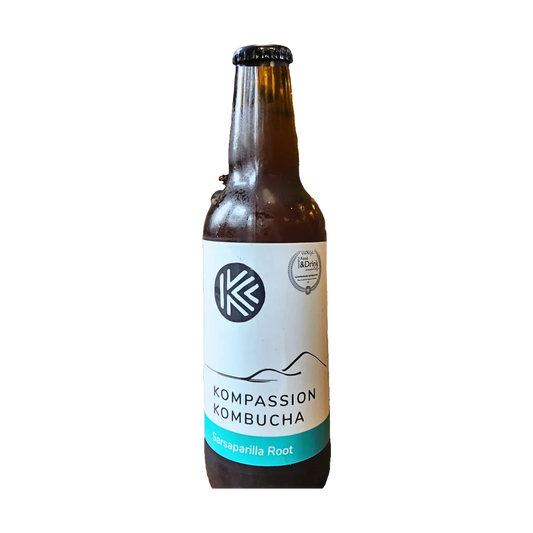 A brown bottle of Kompassion Sarsaparilla Root kombucha with a white label and a teal band.