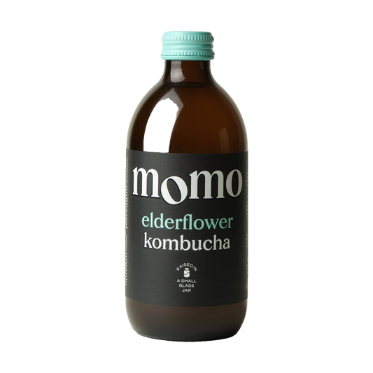 MOMO Elderflower raw kombucha in a brown glass bottle with a mint green cap and black label.