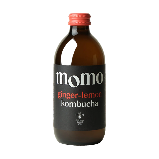 MOMO Ginger-Lemon raw kombucha in a brown glass bottle with a coral cap and black label.