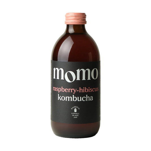 MOMO Raspberry-Hibiscus raw kombucha in a brown glass bottle with a pink cap and black label.