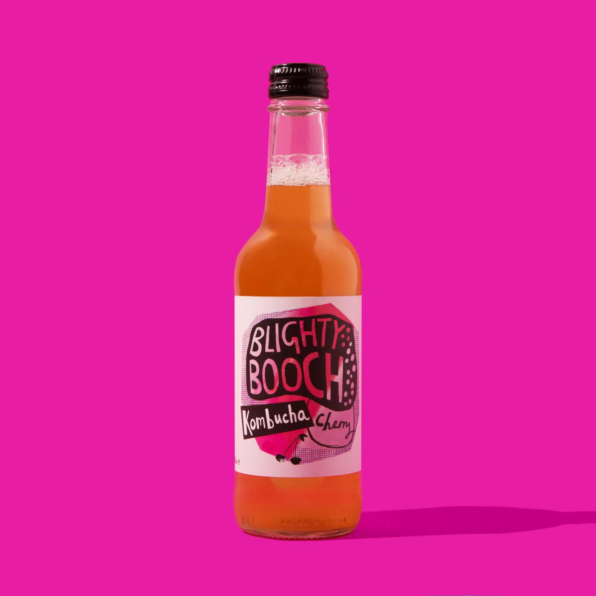 Bottle of Blighty Booch Kombucha Cherry on a pink background