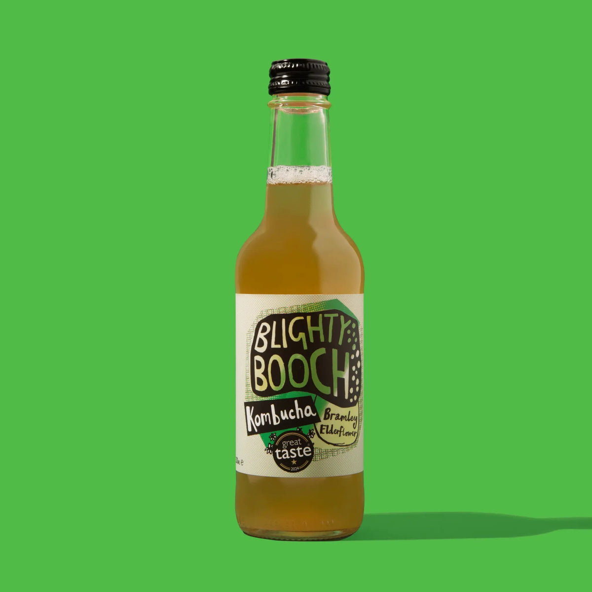 A bottle of Blighty Booch Kombucha beverage with a black cap and cream label, set against a solid bright green background.