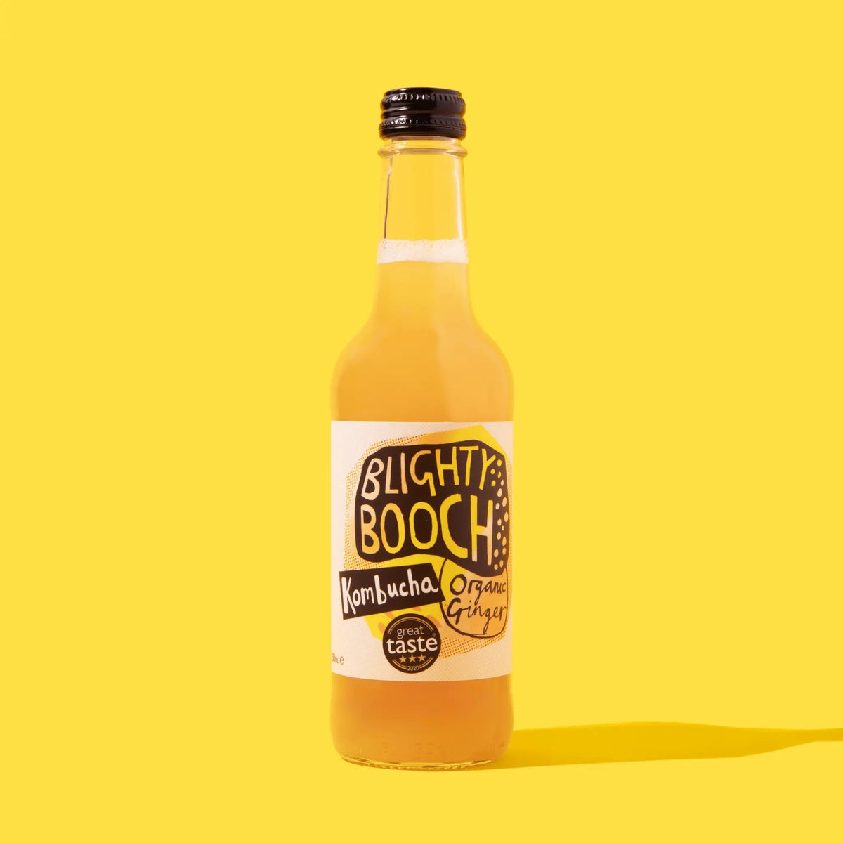 Bottle of Blighty Booch Kombucha on a yellow background